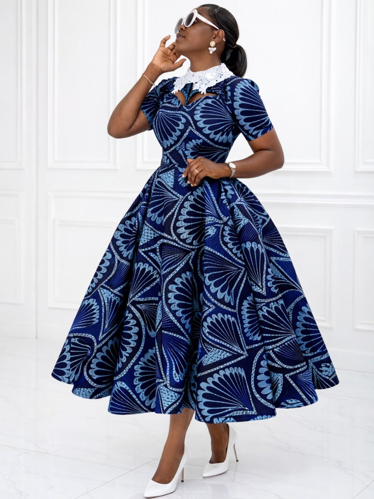 Woman in a blue patterned fit-and-flare dress with white lace collar and heels.