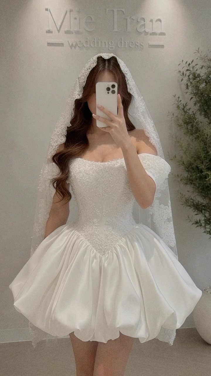 Bride Reception Dress: 17 Ideas for Your Second Look 10 Woman in a short white bridal dress with a puffed skirt and lace veil.