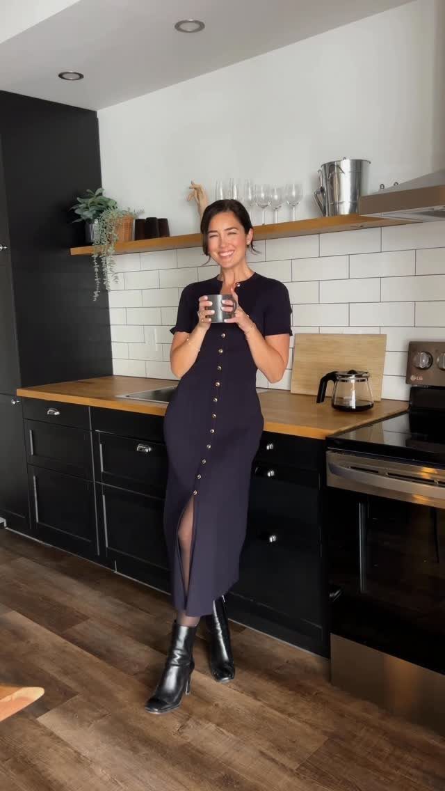 Classy Winter Dresses in 14 Timeless Styles 3 Woman in a navy blue button-down midi dress and black boots in a kitchen