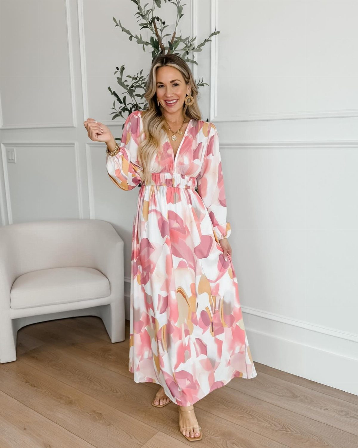 Woman wearing a long white dress with pink and orange floral prints.