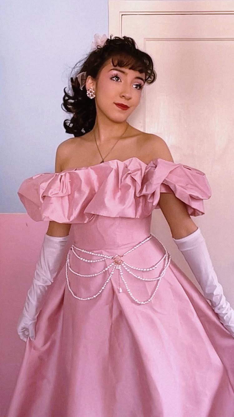 Woman in a pink off-the-shoulder satin prom dress with white opera gloves.