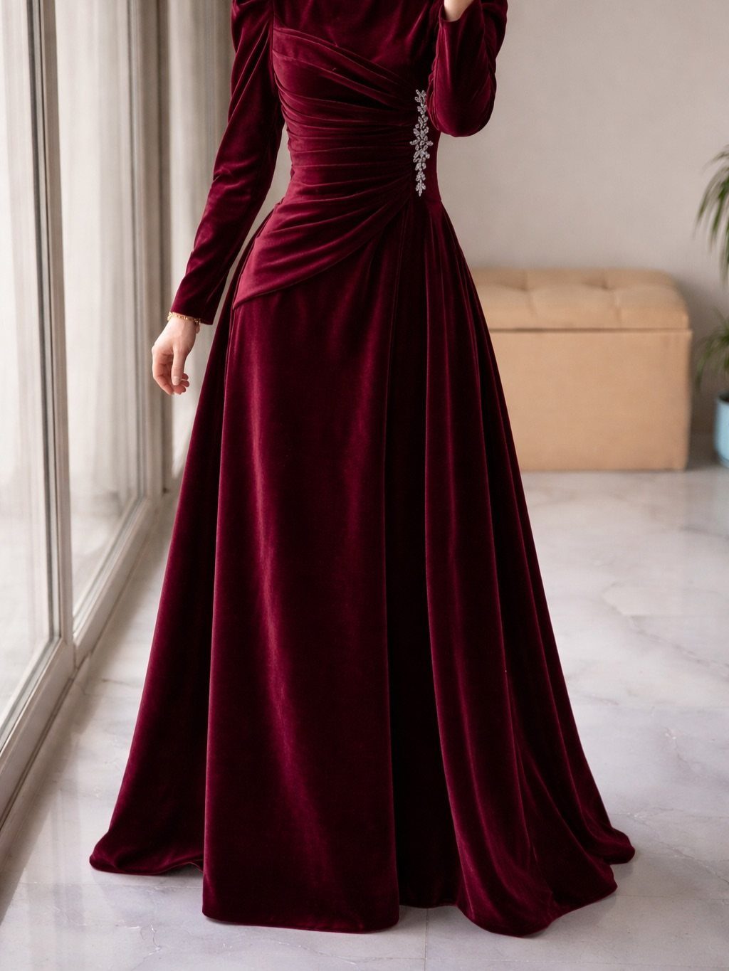 Elegant Dresses for Wedding Guests Over 50 (8 Refined Styles) 3 Burgundy velvet floor-length gown with long sleeves and a sparkling waist embellishment.