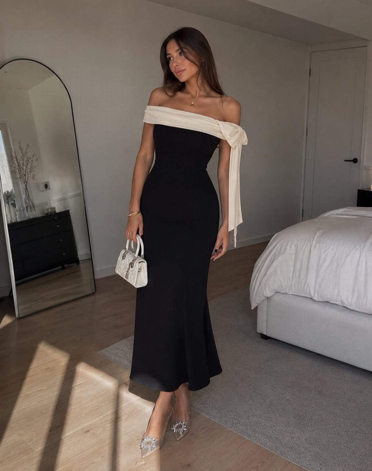 Woman in a black off-the-shoulder evening gown with a white neckline wrap.