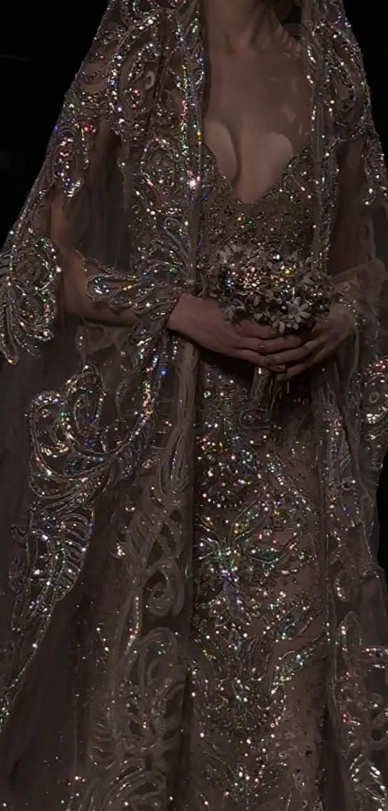 Intricately beaded champagne gown and cape with a small white floral bouquet