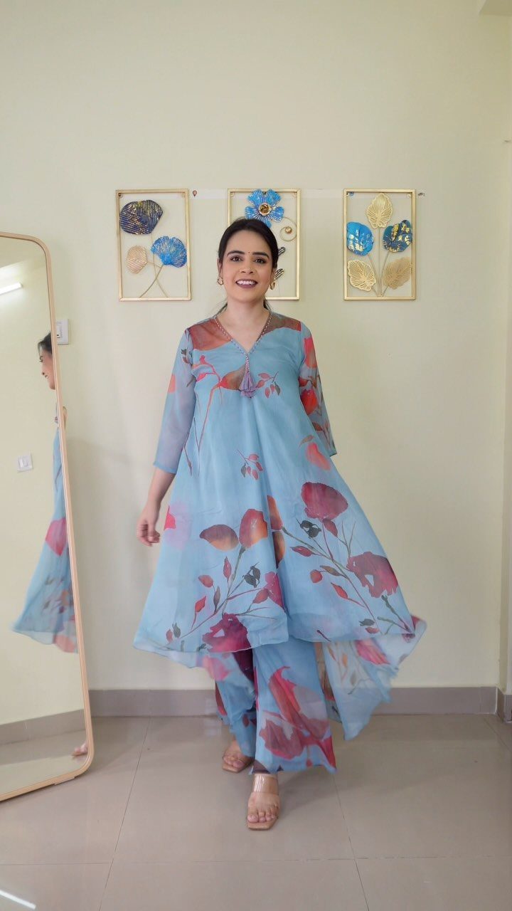 Woman wearing a light blue floral print co-ord set with matching trousers.