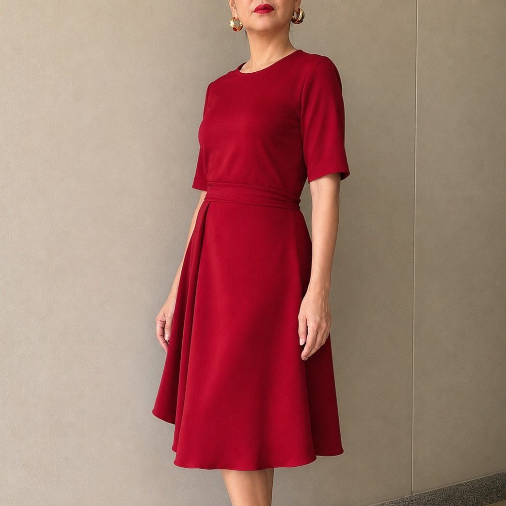 Knee-Length Cocktail Dress Styles: 15 Chic Ideas 2 Woman in a red knee-length fit-and-flare cocktail dress standing against a neutral wall.