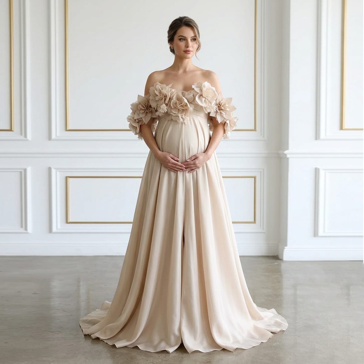 Pregnant woman in a champagne off-the-shoulder satin maternity gown with floral shoulder details.