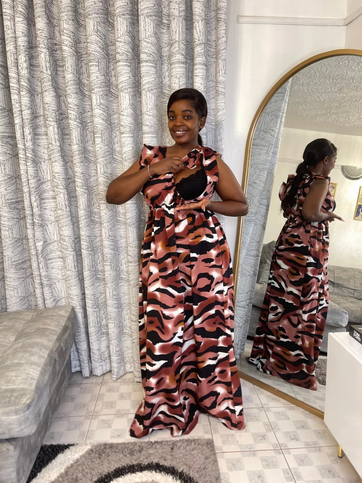 Woman wearing a brown and black animal print maternity maxi dress in a room