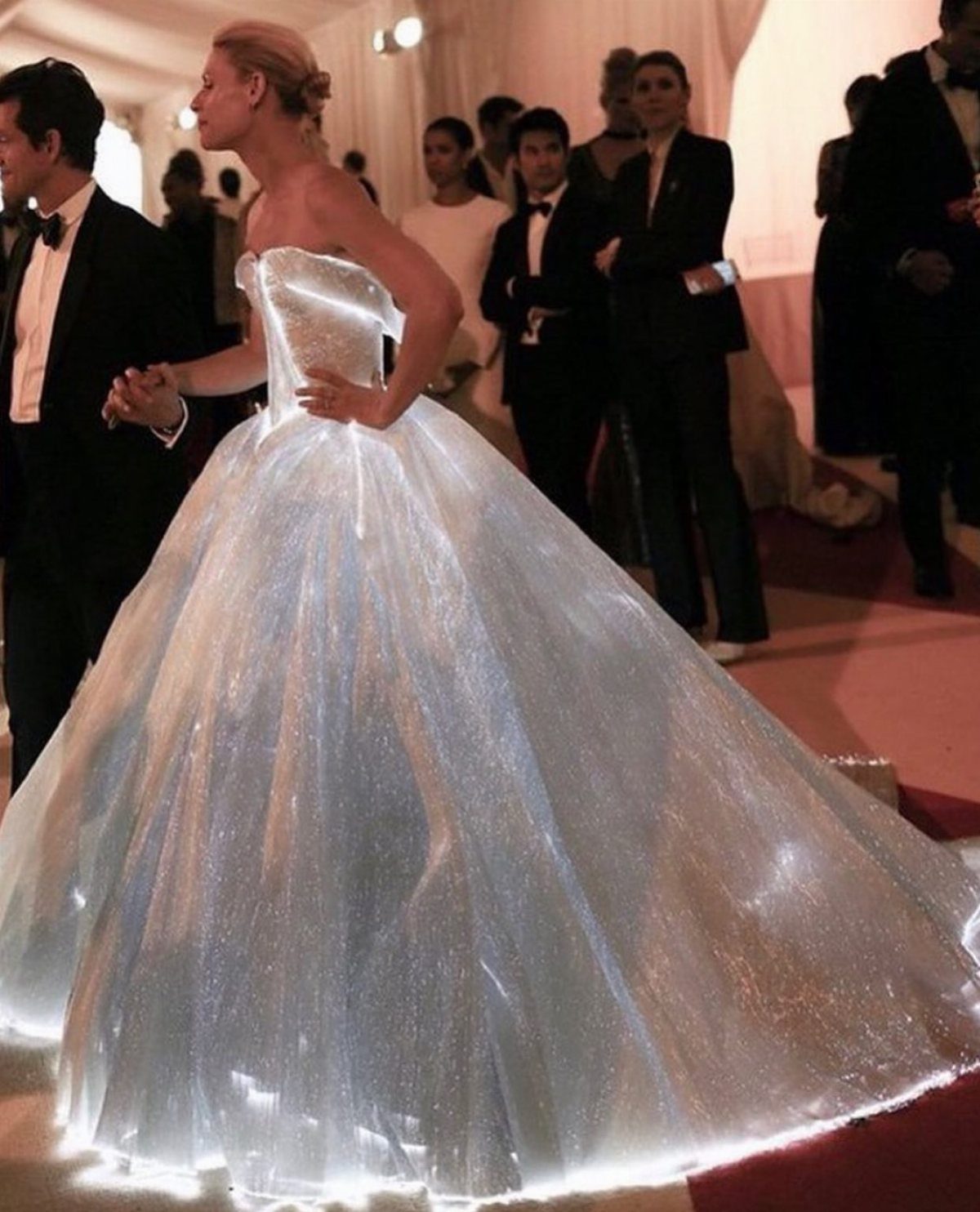 12 Met Gala Dresses That Defined Red Carpet Fashion 8 Woman in a glowing white strapless ball gown on a red carpet at an event