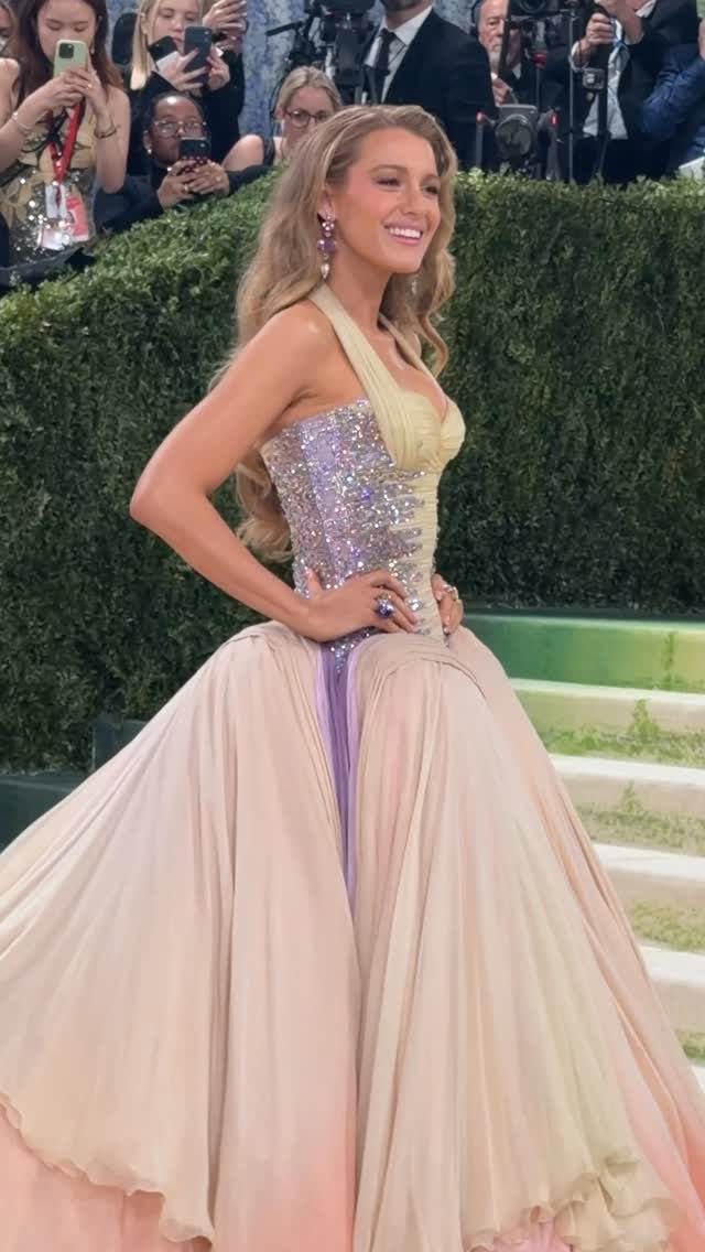 12 Met Gala Dresses That Defined Red Carpet Fashion 11 Woman in a voluminous yellow and purple sequined gown posing at the Met Gala.