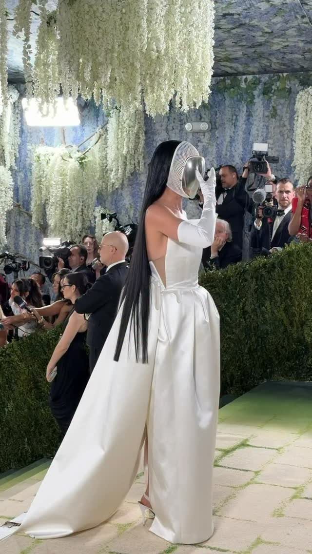 12 Met Gala Dresses That Defined Red Carpet Fashion 2 Person in a white satin gown and mirrored mask at the Met Gala.
