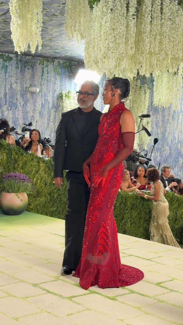 12 Met Gala Dresses That Defined Red Carpet Fashion 4 Woman in a sparkling red gown and man in a black suit posing.