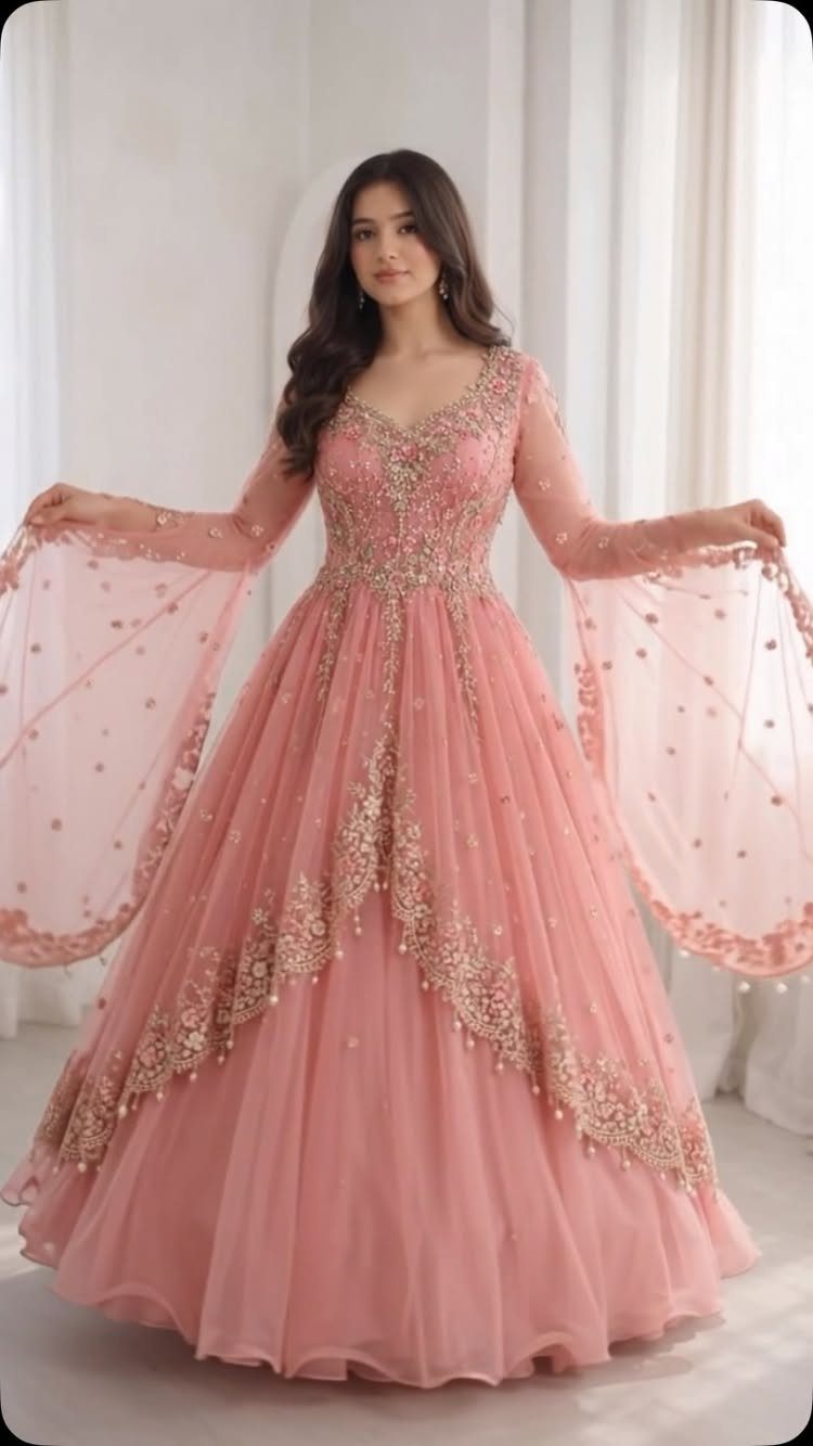 Woman wearing a blush pink wedding dress with gold embroidery and bell sleeves.