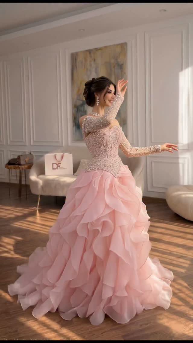 Woman in a light pink wedding dress with a ruffled tulle skirt and beaded bodice.
