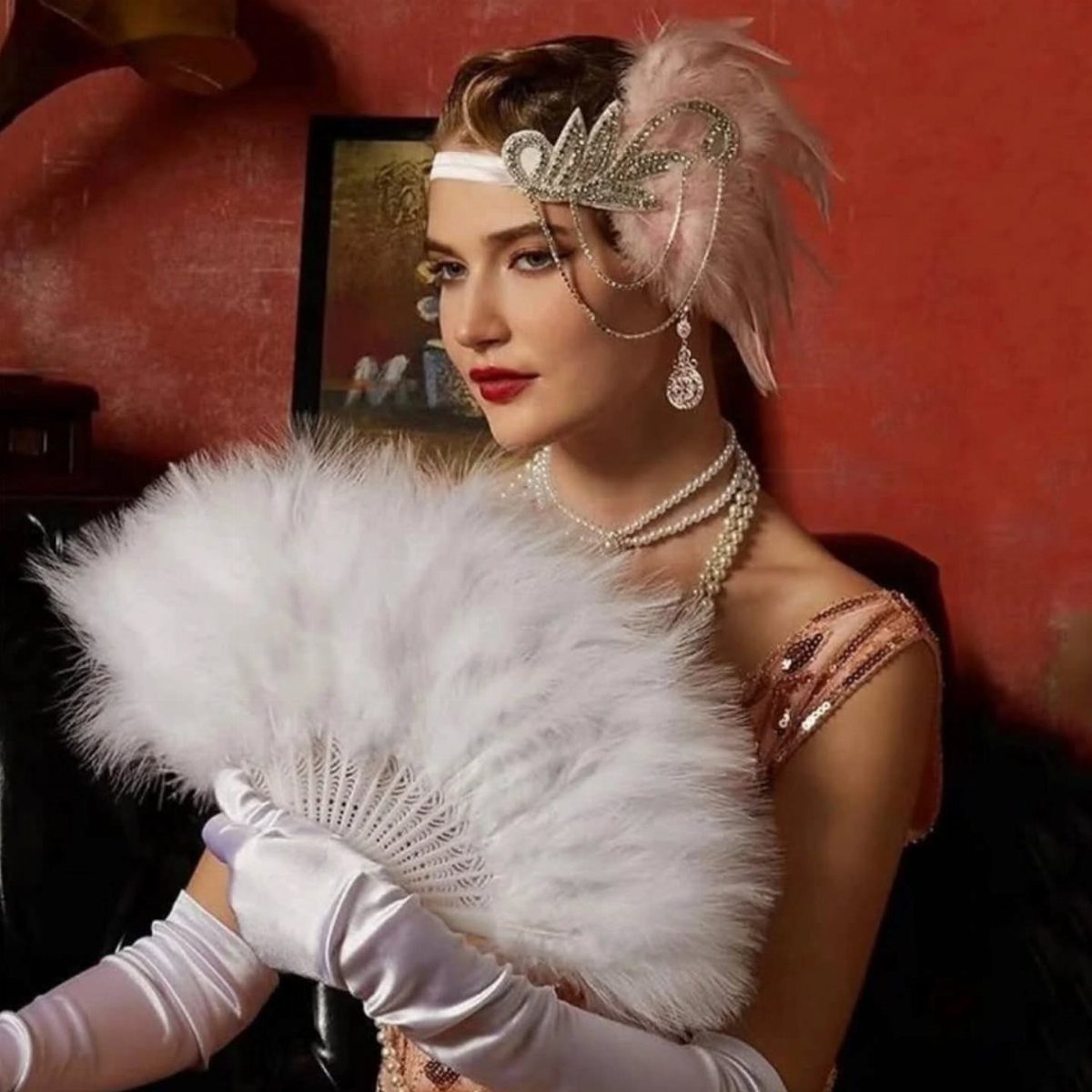 Woman in 1920s attire wearing white long gloves and a feathered headpiece.