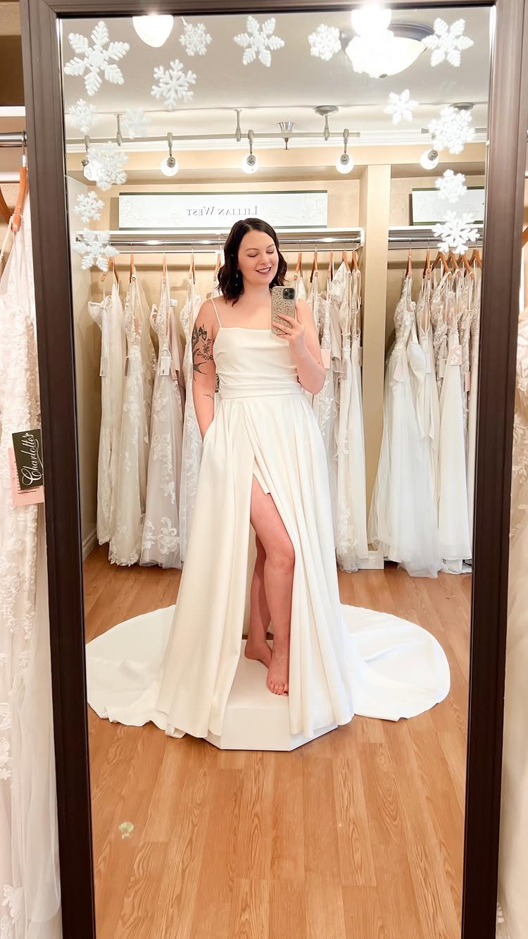 Simplistic Wedding Dress Ideas: 6 Elegant Styles to Consider 3 Woman in a white stretch satin wedding dress with a high leg slit.
