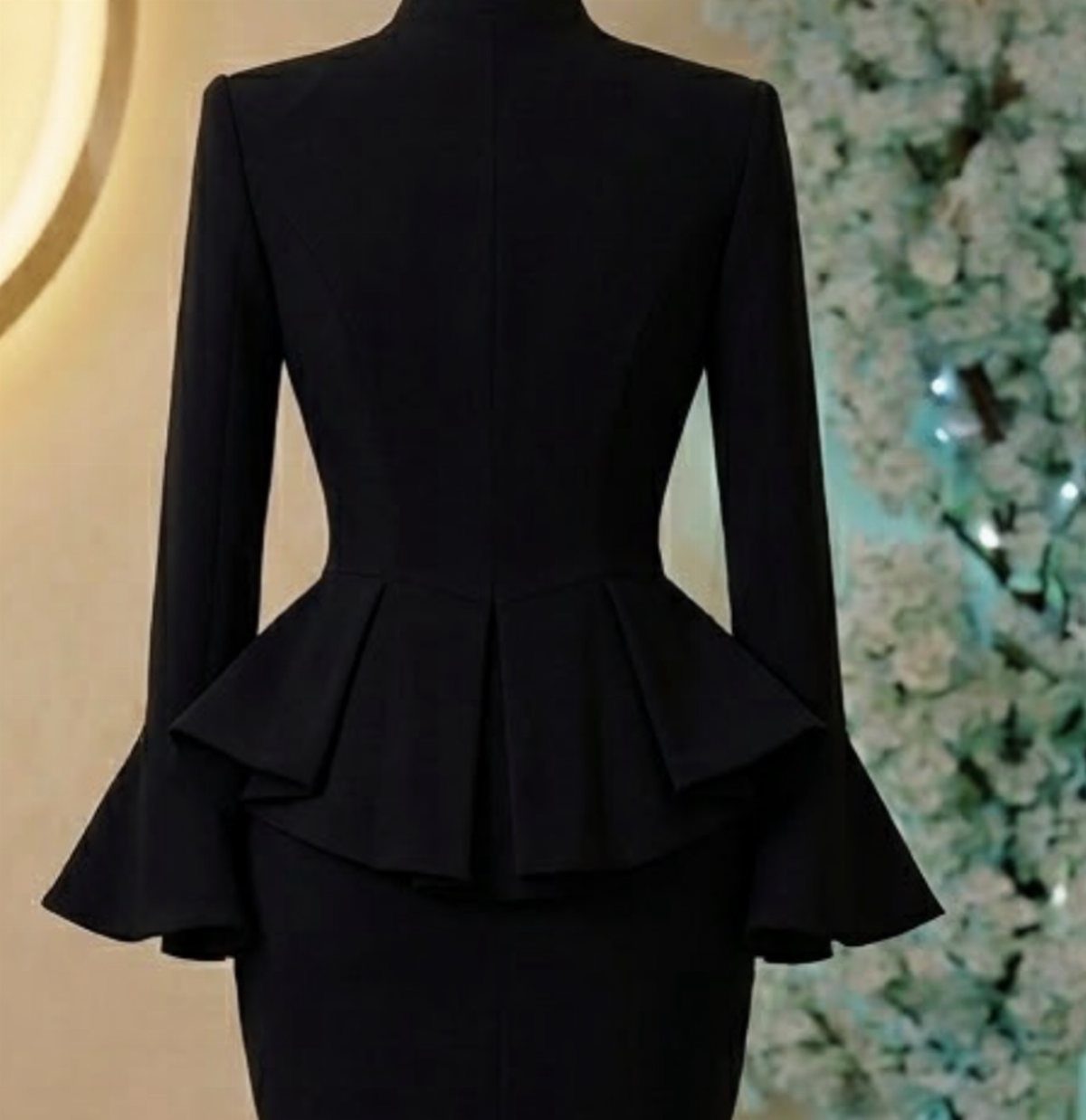 9 Stylish Work Dresses That Keep You Polished All Day 7 Black long-sleeved peplum dress with flared sleeves on a mannequin.