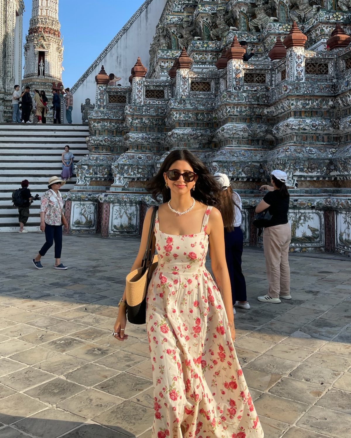 Are Summer Tank Dresses the Season's Must-Have? 8 Styles 6 Woman in a white floral midi tank dress posing before an ornate temple.