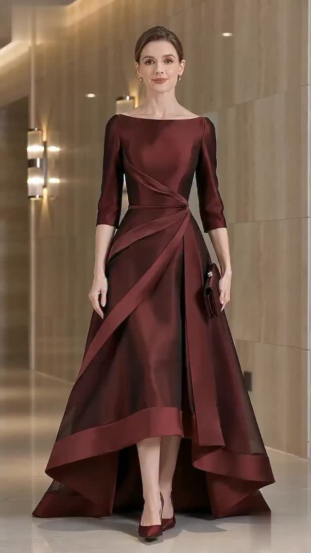 Woman in a formal deep red satin high-low evening gown in a modern hallway