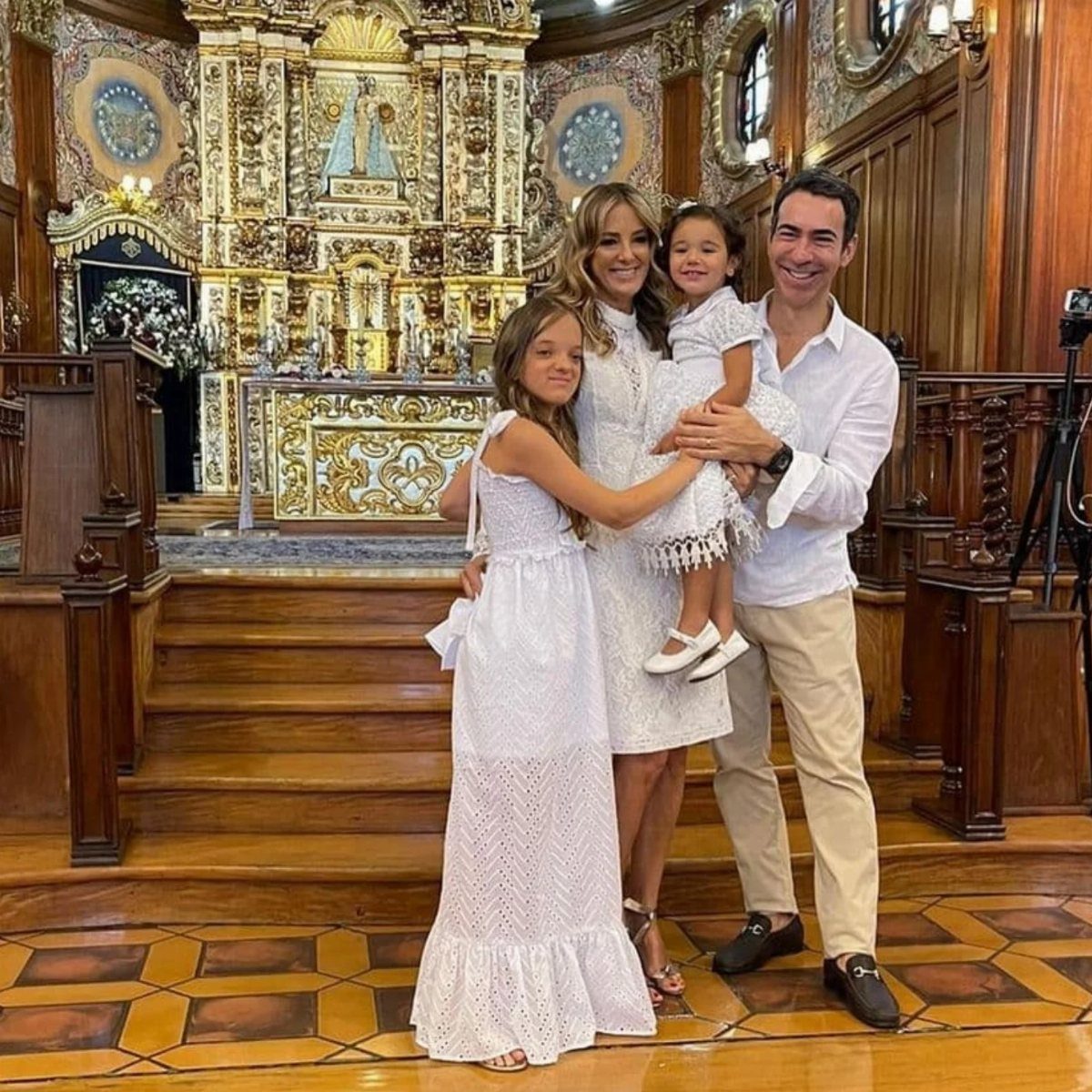Family posing in a church with women and girls wearing white cotton dresses.