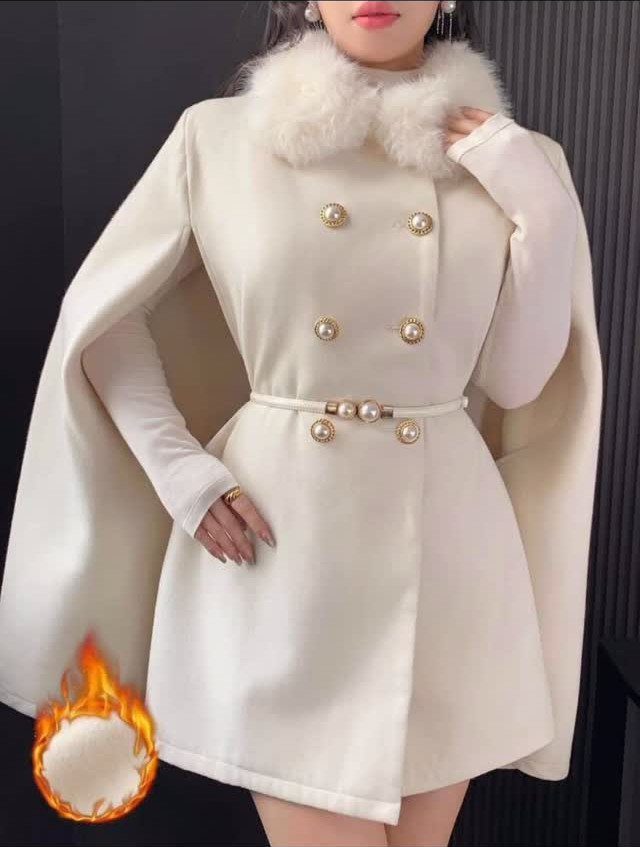 Woman wearing a white double-breasted coat dress with a faux-fur collar and gold buttons.