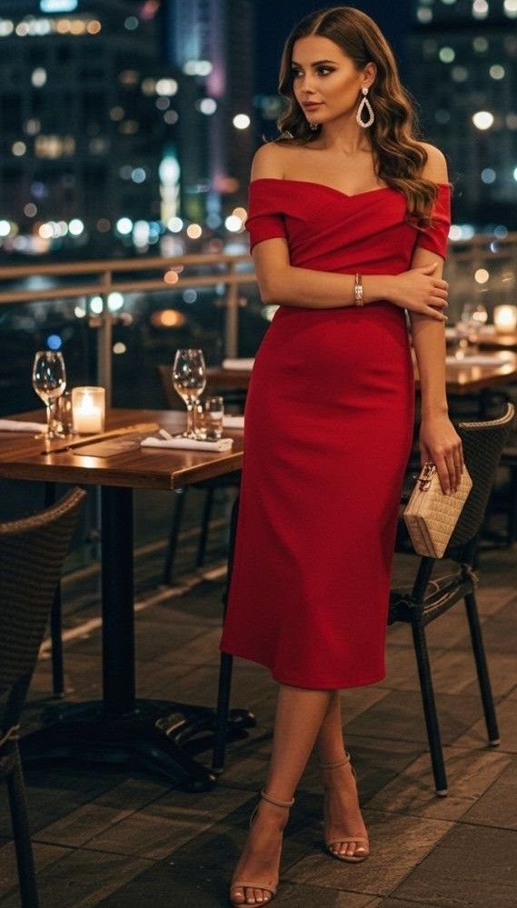 Woman in a red off-the-shoulder midi cocktail dress standing on a city rooftop terrace.