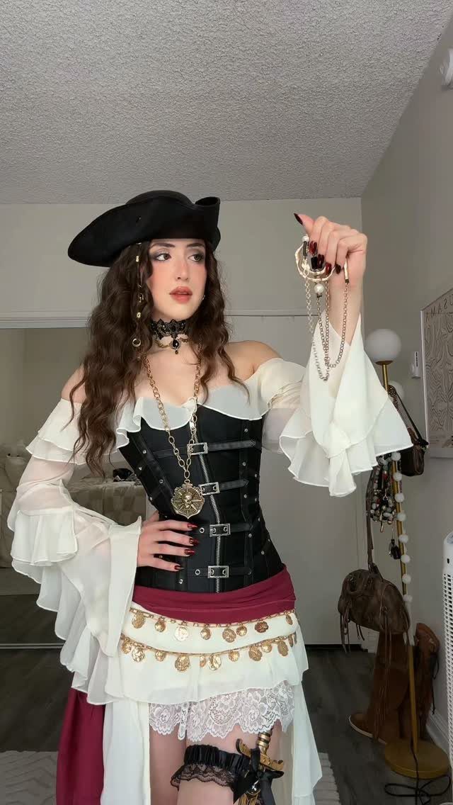 Womens Pirate Dress Styles: 8 Looks from Classic to Bold 2 Woman in a pirate costume wearing a black buckled corset and tricorn hat.
