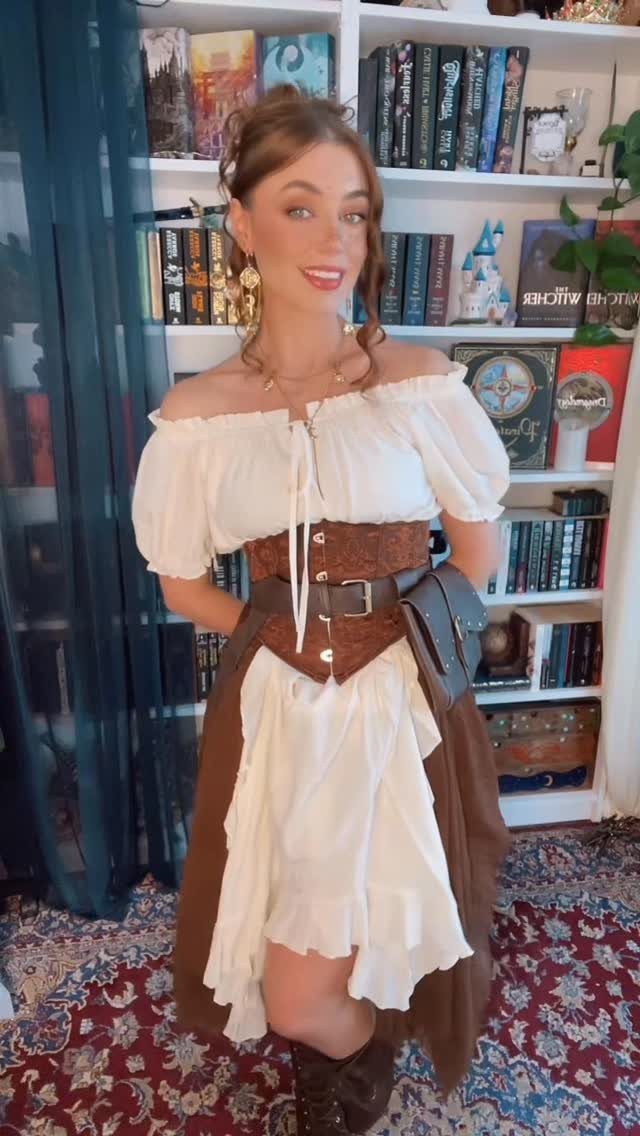 Womens Pirate Dress Styles: 8 Looks from Classic to Bold 5 Woman wearing a white peasant blouse and brown corset pirate dress in a room.