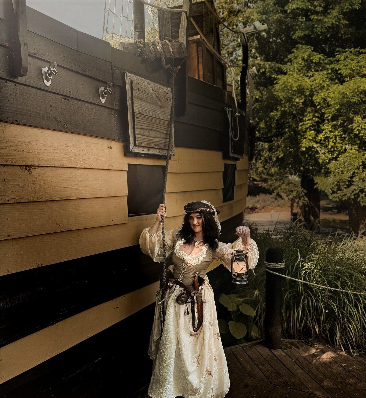 Womens Pirate Dress Styles: 8 Looks from Classic to Bold 6 Woman in a cream pirate dress holding a lantern beside a wooden ship