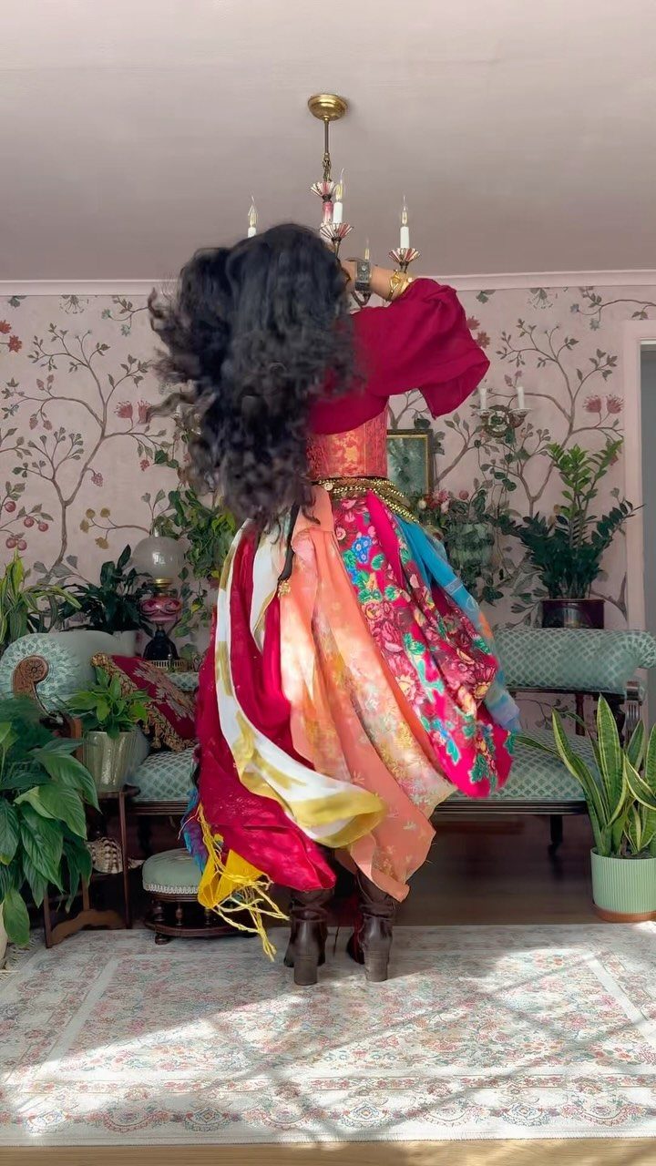 Womens Pirate Dress Styles: 8 Looks from Classic to Bold 3 Person wearing a layered pirate outfit with a red top and colorful floral skirt.
